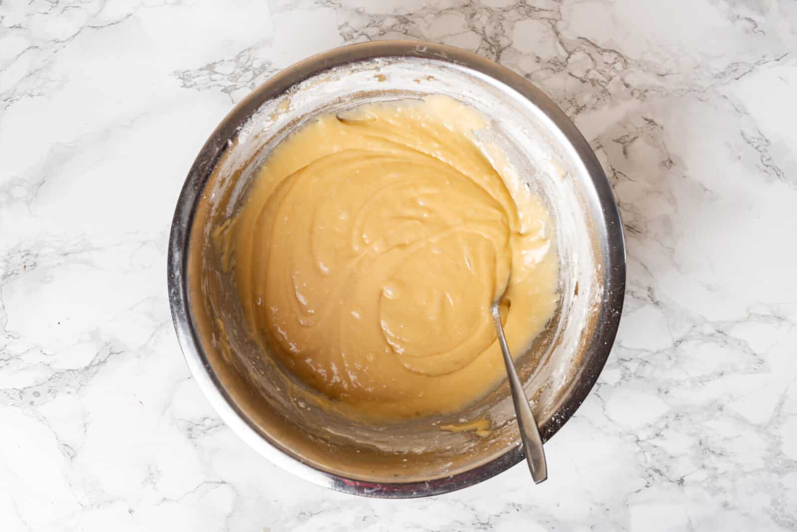 Added dry ingredients and baking soda mix to the batter in a silver bowl.