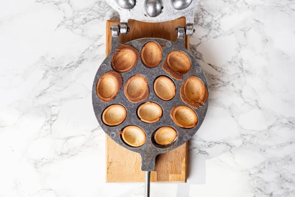 Cooked walnut cookie shells in a cookie pan.