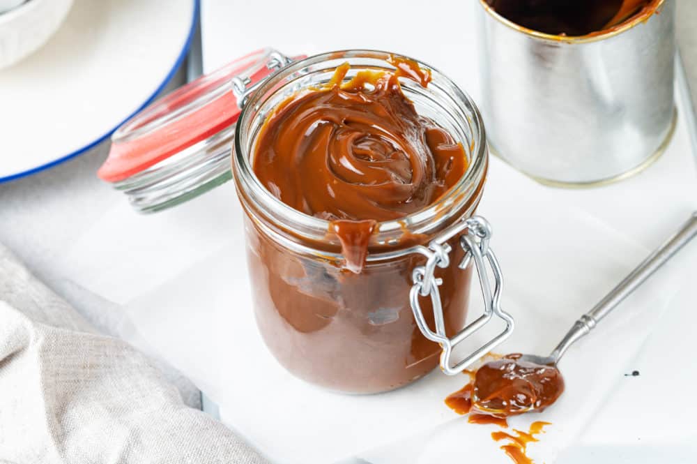 dulce-de-leche-in-a-glass-jar-with-a-spoon-on-the-side
