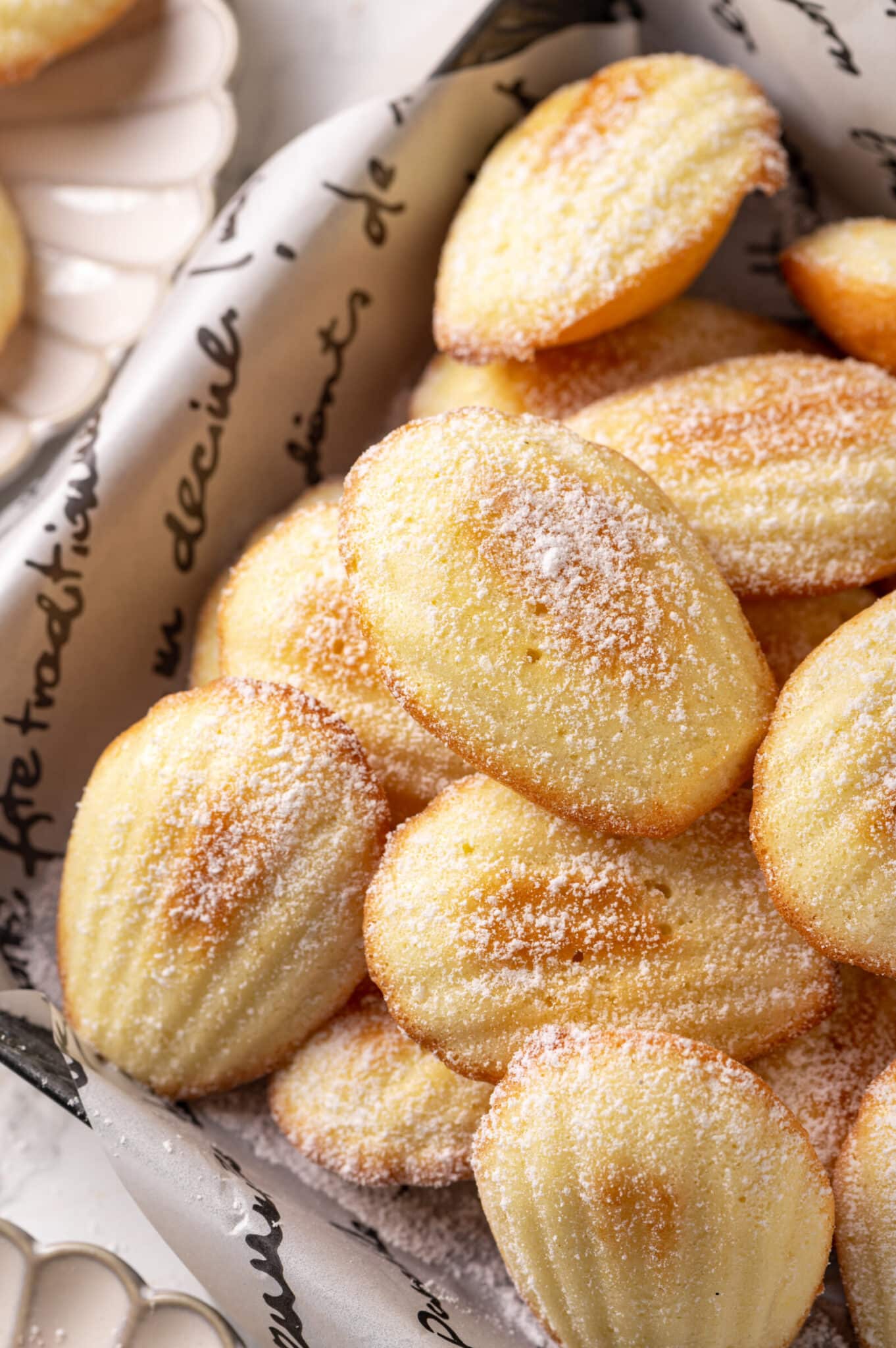 Madeleines in a tin with powdered sugar on top.