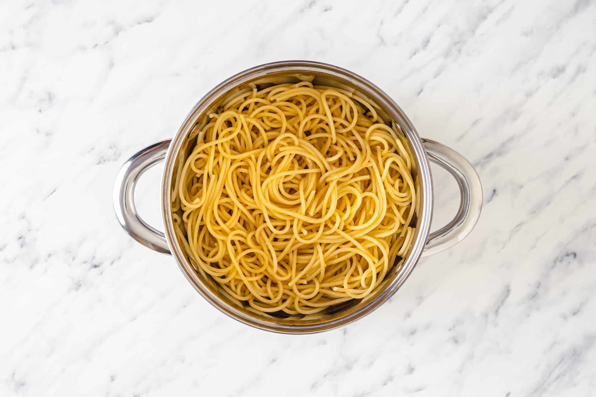 a silver pot of cooked spaghetti.
