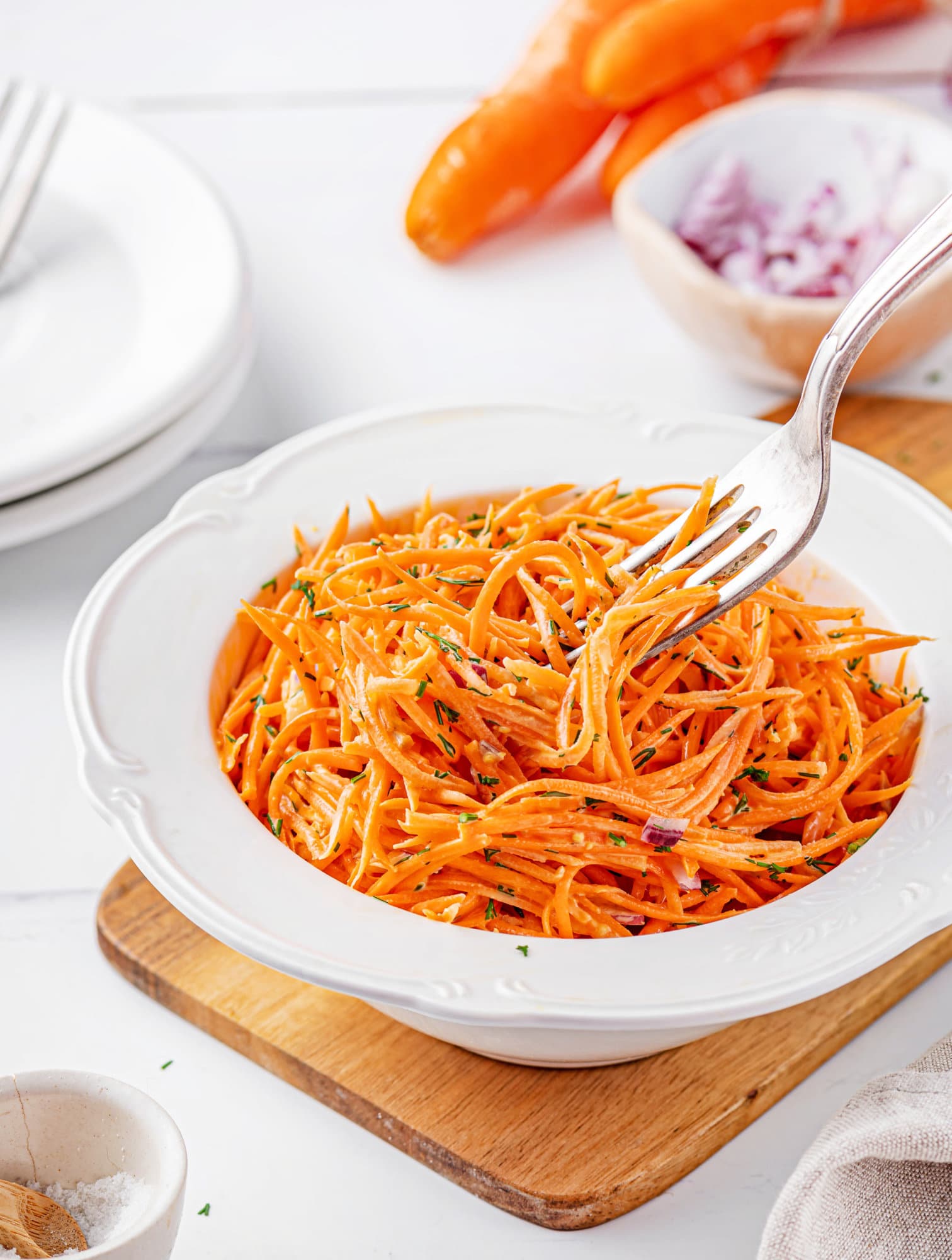 carrot-salad-in-a-white-bowl-on-a-wooden-board-with-a-fork