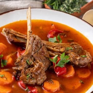 soup with lamb chops on top and sprinkled parsley.