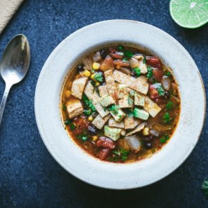 chicken-soup-in-a-white-bowl-with-a-spoon-lime-and-cilantro-on-the-side