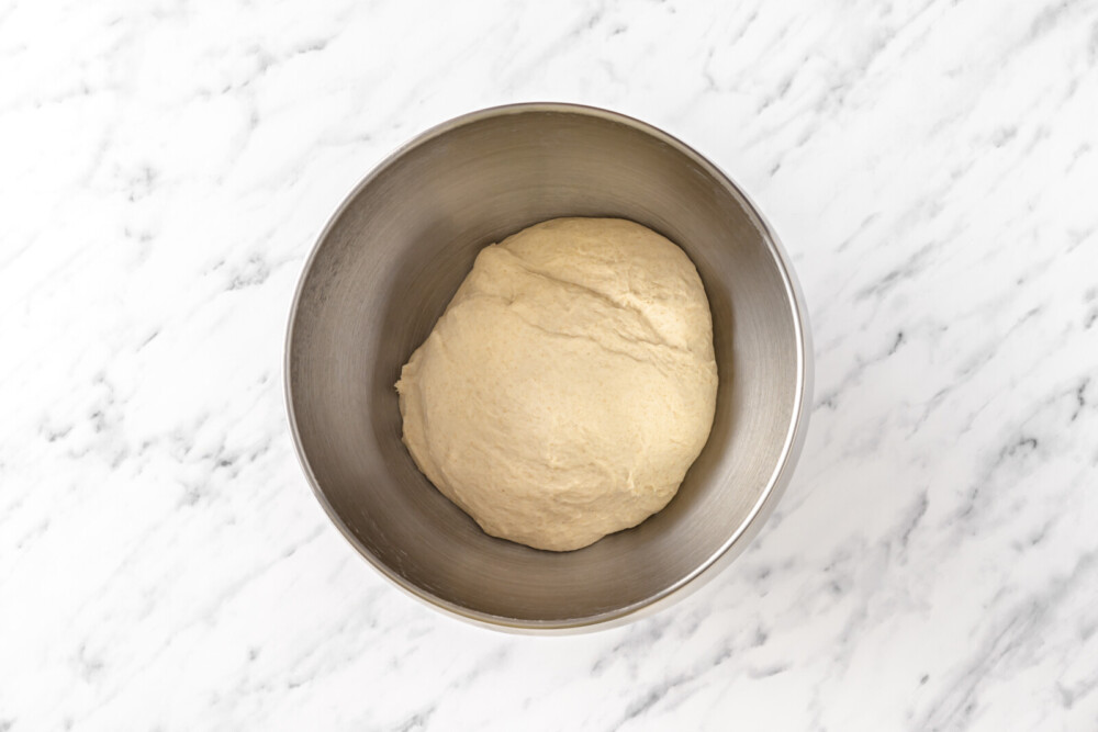 raw bread dough in a silver bowl.