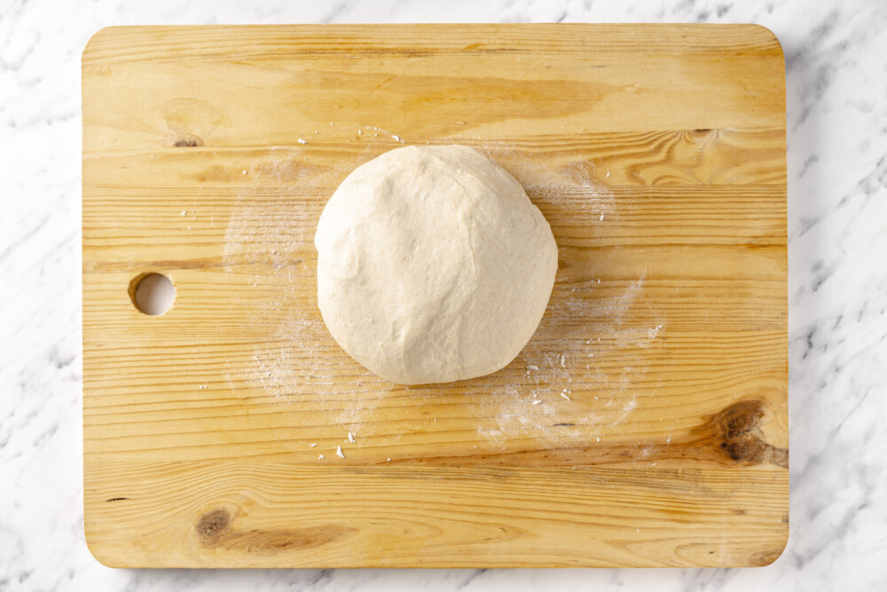 dough on a wooden board with flour.