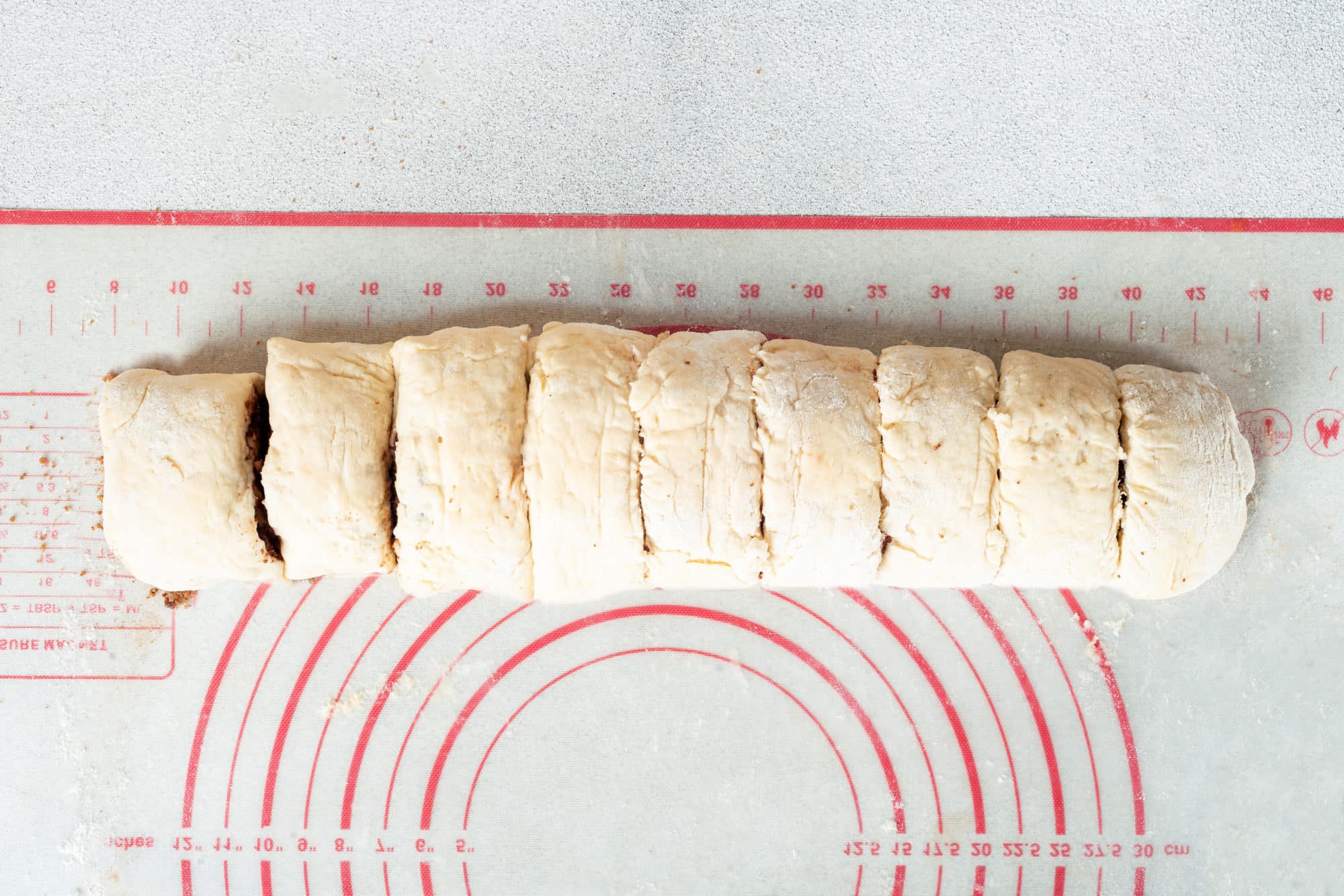 Cinnamon rolls cut from a roll of cinnamon roll dough.