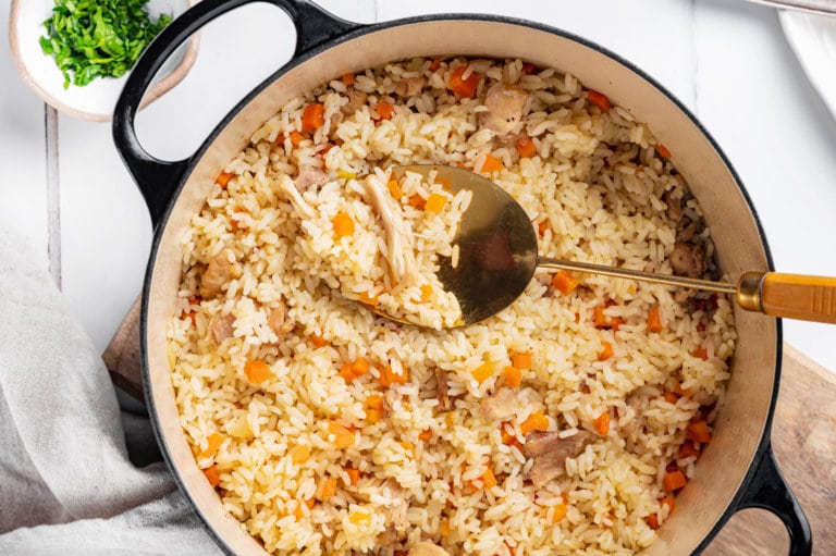 Rice pilaf on a pot with a large spoon.