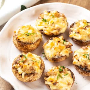 A plate of baked and stuffed mushroom caps.