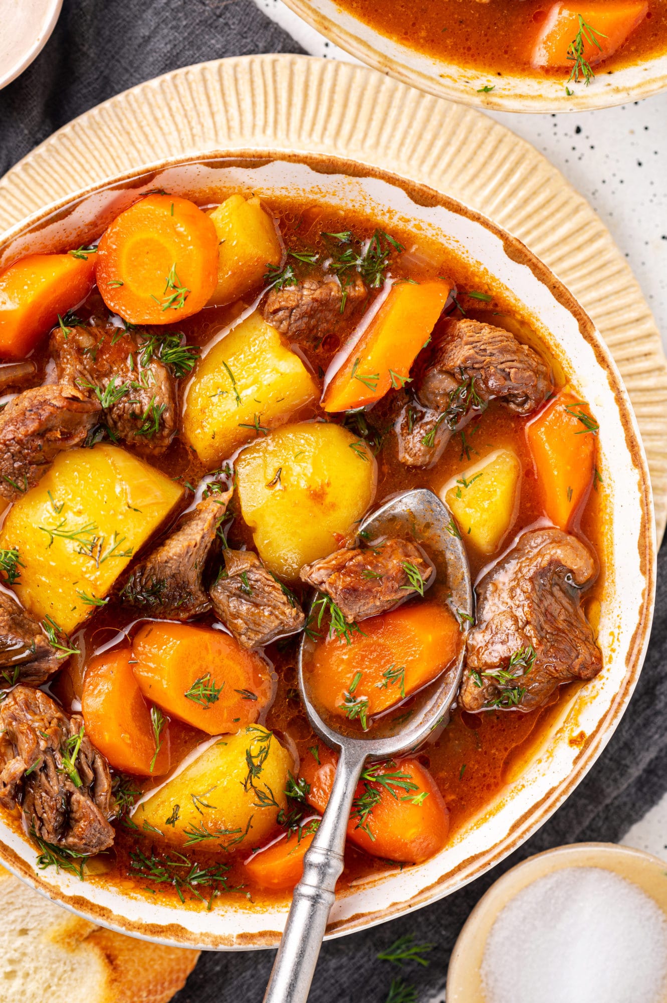 beef-stew-in-a-bowl-on-a-plate-with-a-spoon