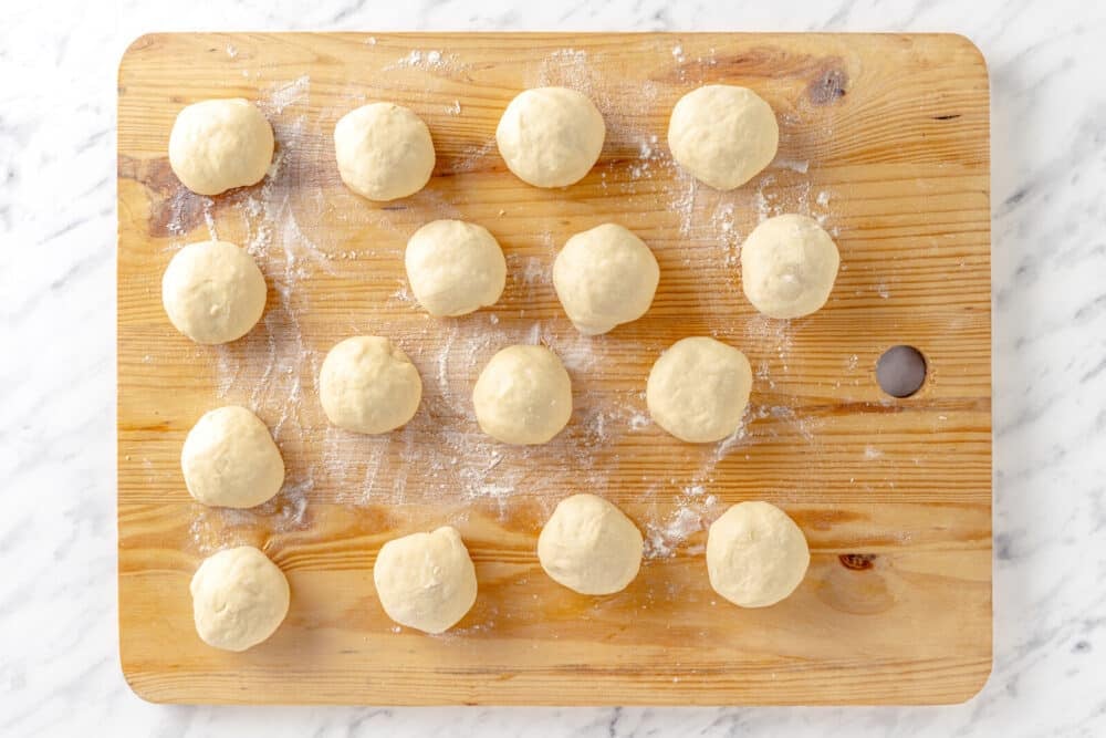 Sectioned out dough into small balls on a floured work surface.