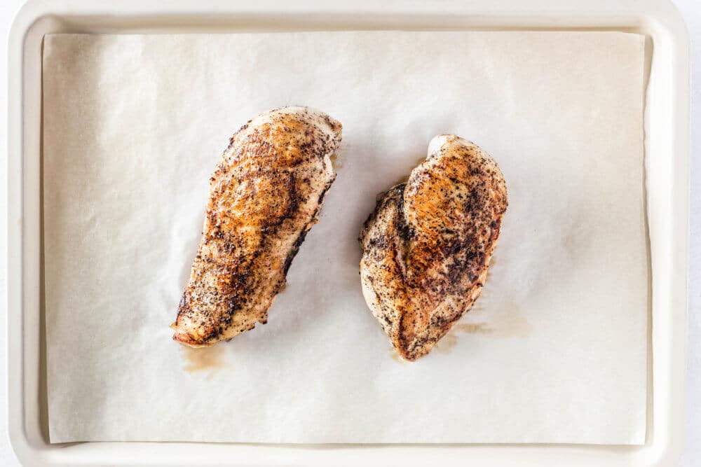 cooked chicken breast on parchment paper
