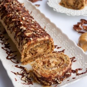 honey-pecan-roll-on-a-white-plate-with-a-honey-mixer-on-the-side