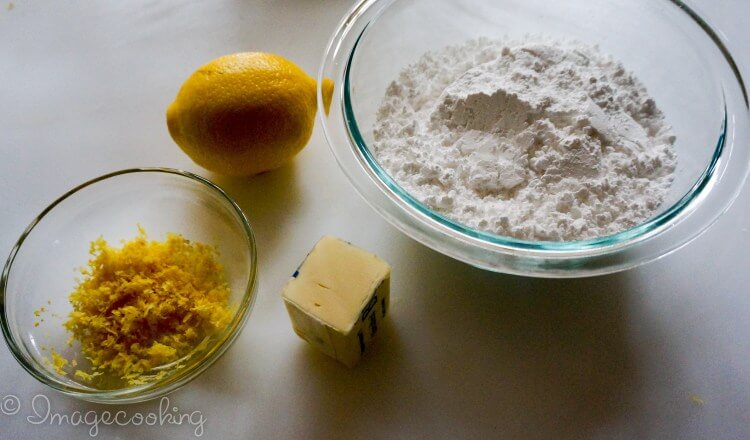 lemon-zest-in-a-clear-bowl-a-lemon-and-butter-on-the-side-and-a-clear-bowl-of-flour