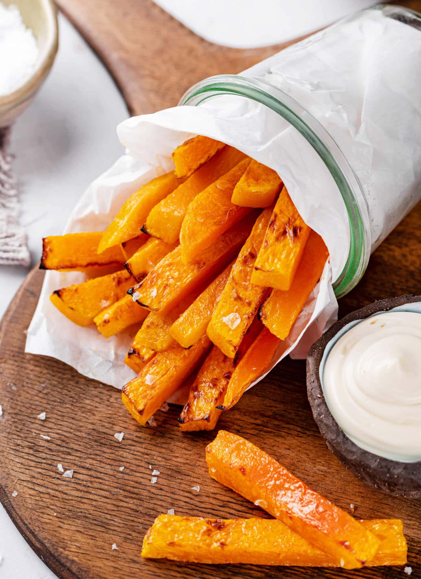 butternut-squash-fries-on-a-wooden-board-in-a-cup-with-sauce-on-the-side