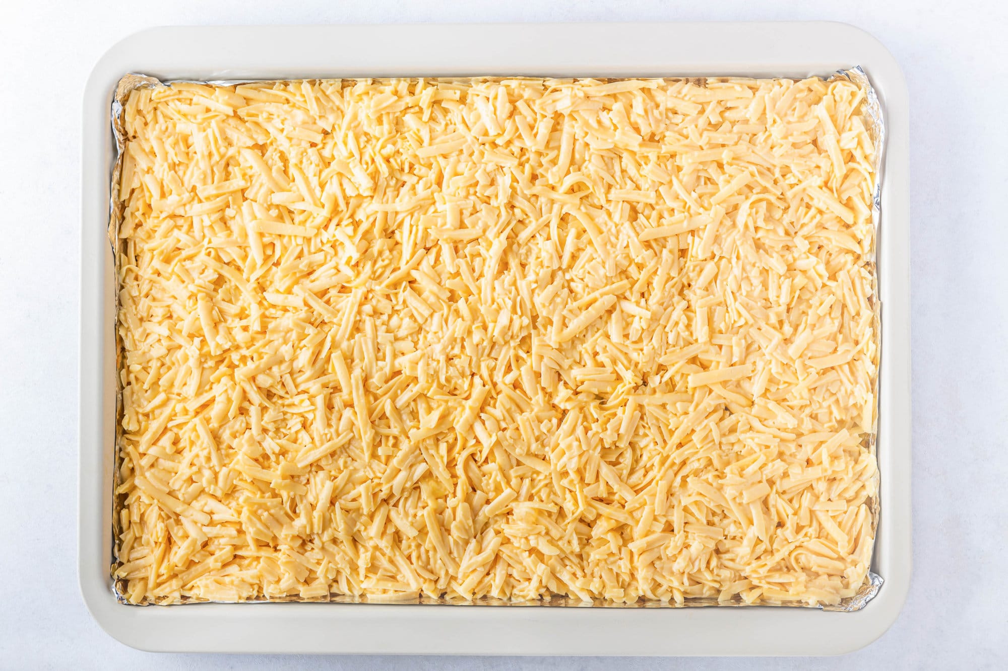 Shredded cheese laid out on a baking sheet.