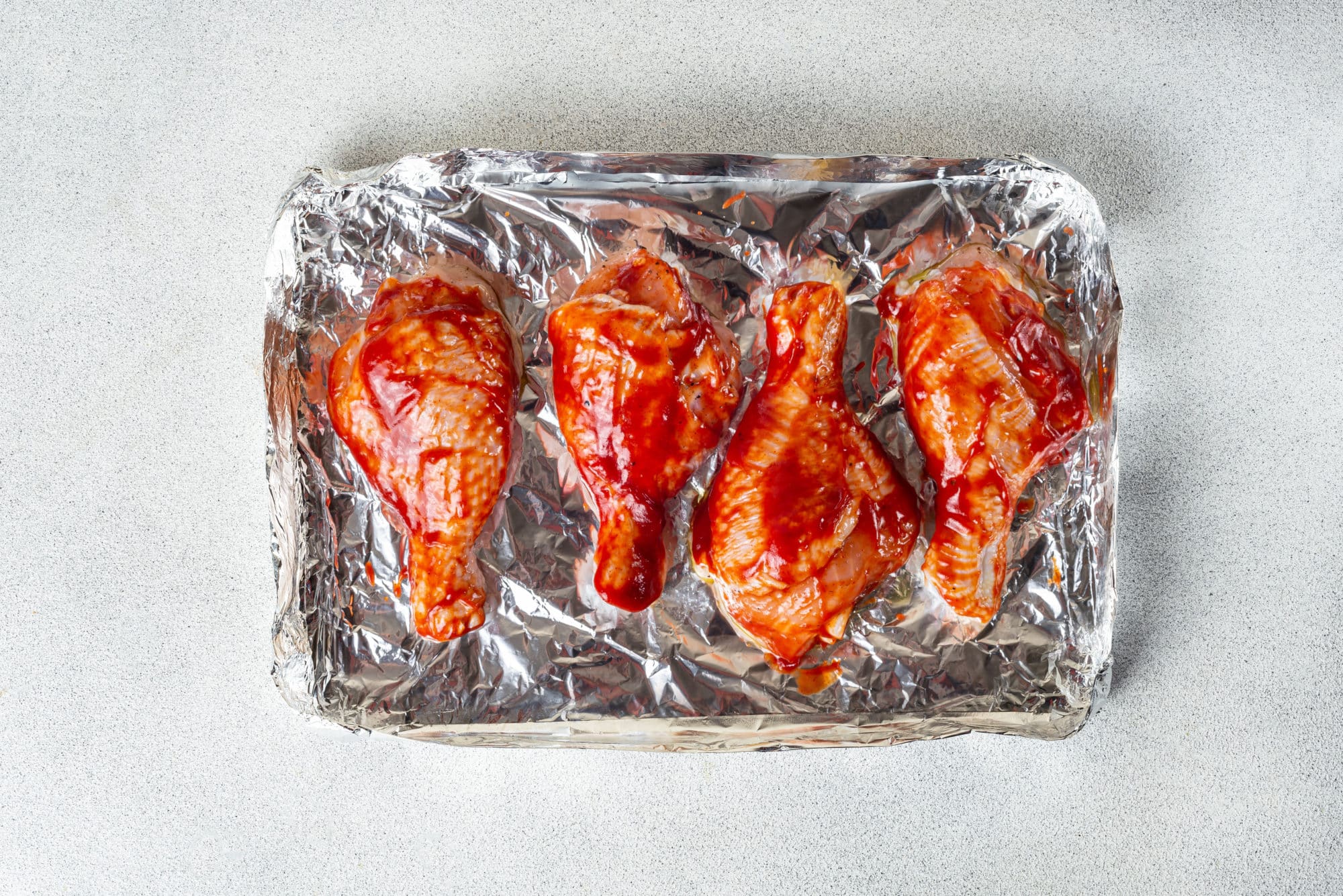 chicken-drumsticks-on-foil-brushed-with-barbecue-sauce