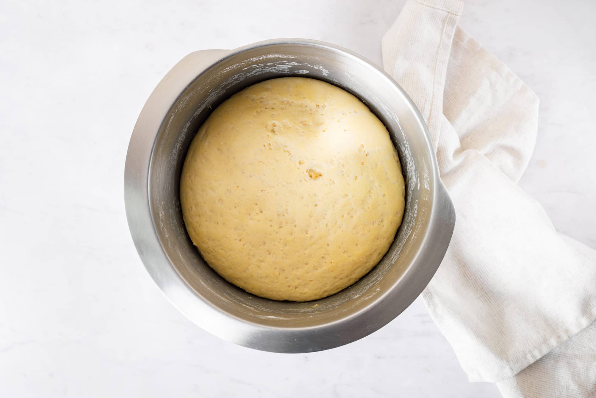 Risen dough for piroshki in a bowl.