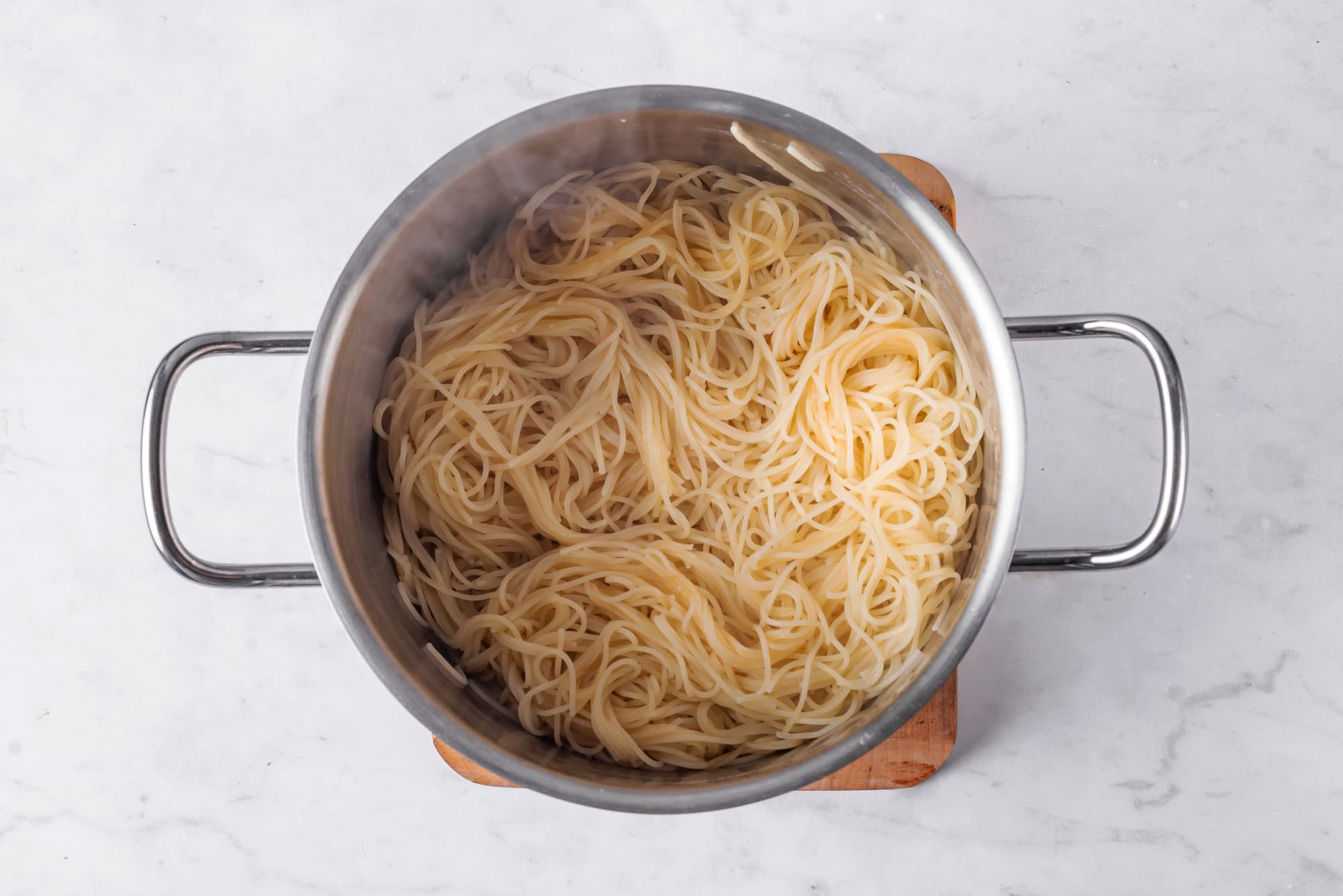 capellini-pasta-in-a-silver-pot-on-a-wooden-board