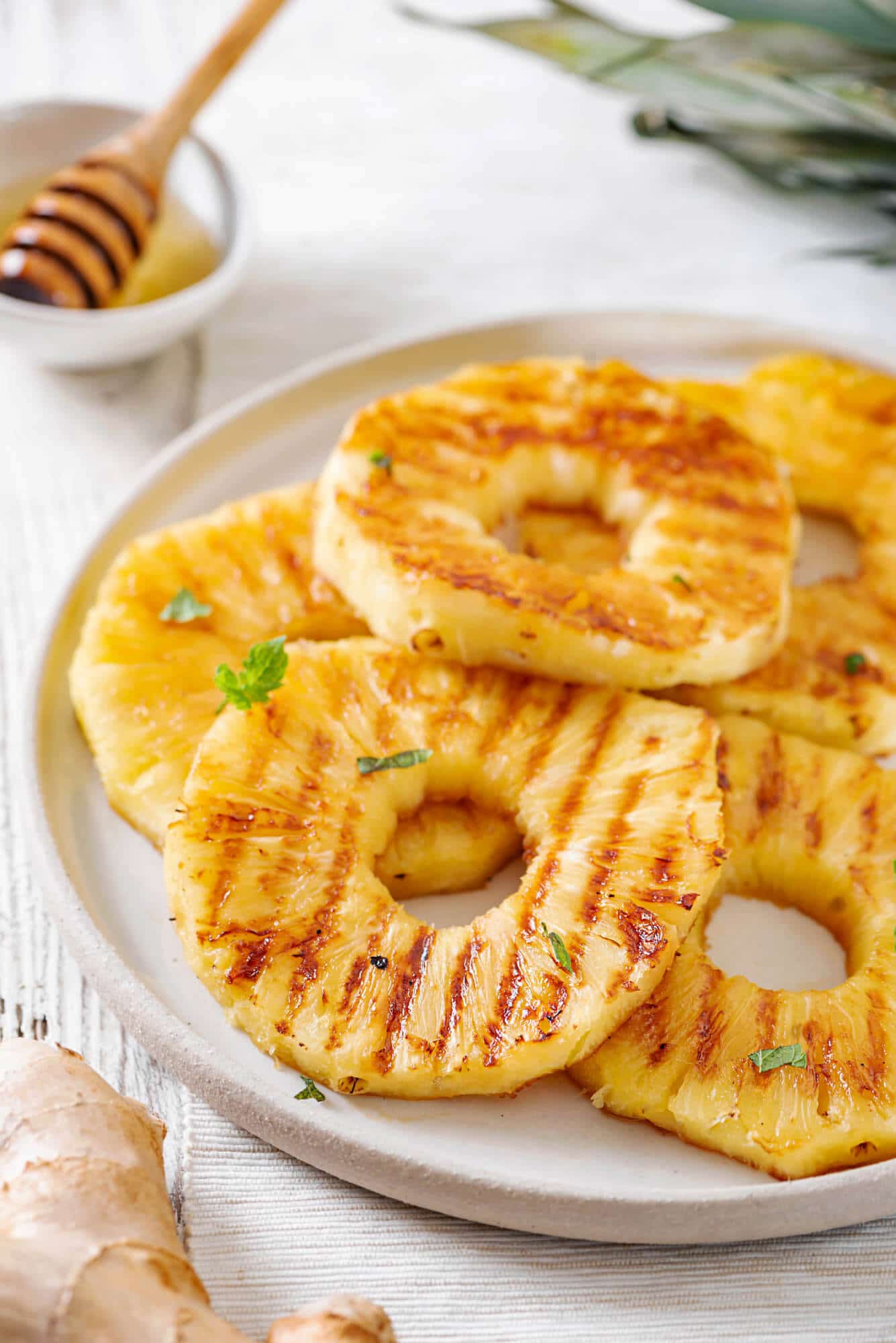pineapple-slices-on-a-white-plate-with-a-bowl-of-honey-with-a-honey-dipper
