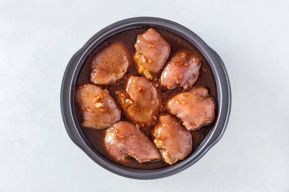 raw-chicken-thighs-in-a-black-dish-with-marinade-sauce