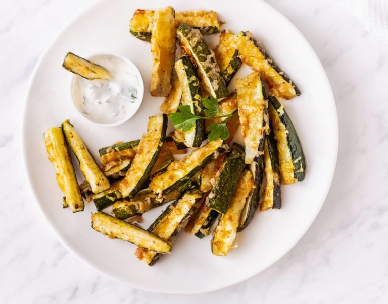 zucchini-bites-on-a-white-plate-with-a-bowl-of-dip-on-the-side