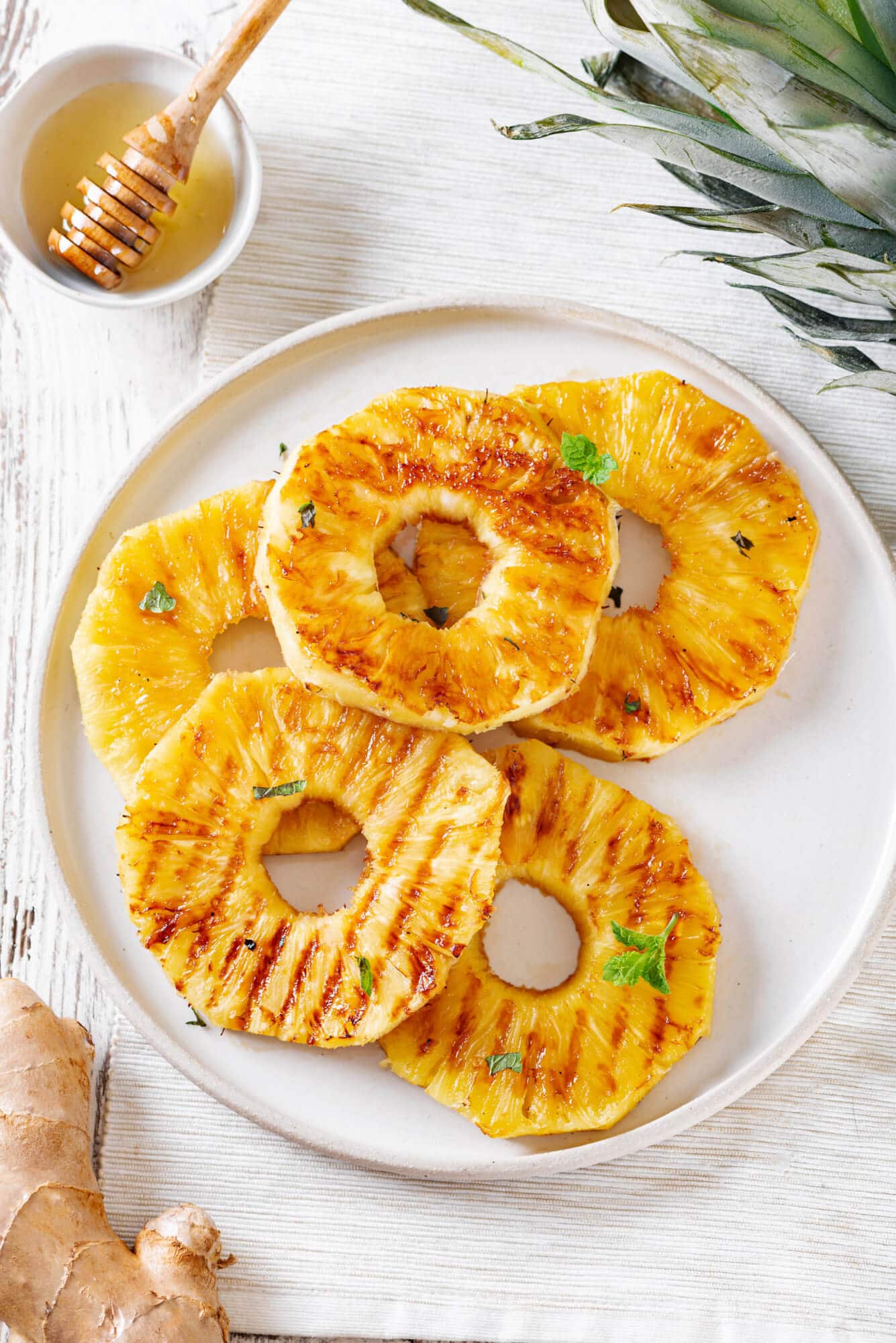 pineapple-slices-on-a-white-plate-with-a-bowl-of-honey-with-a-honey-dipper