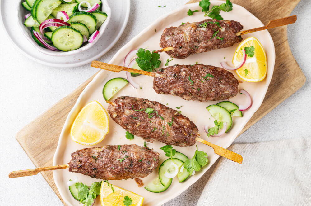 Lamb Kebab on a plate with lemon and cucumber