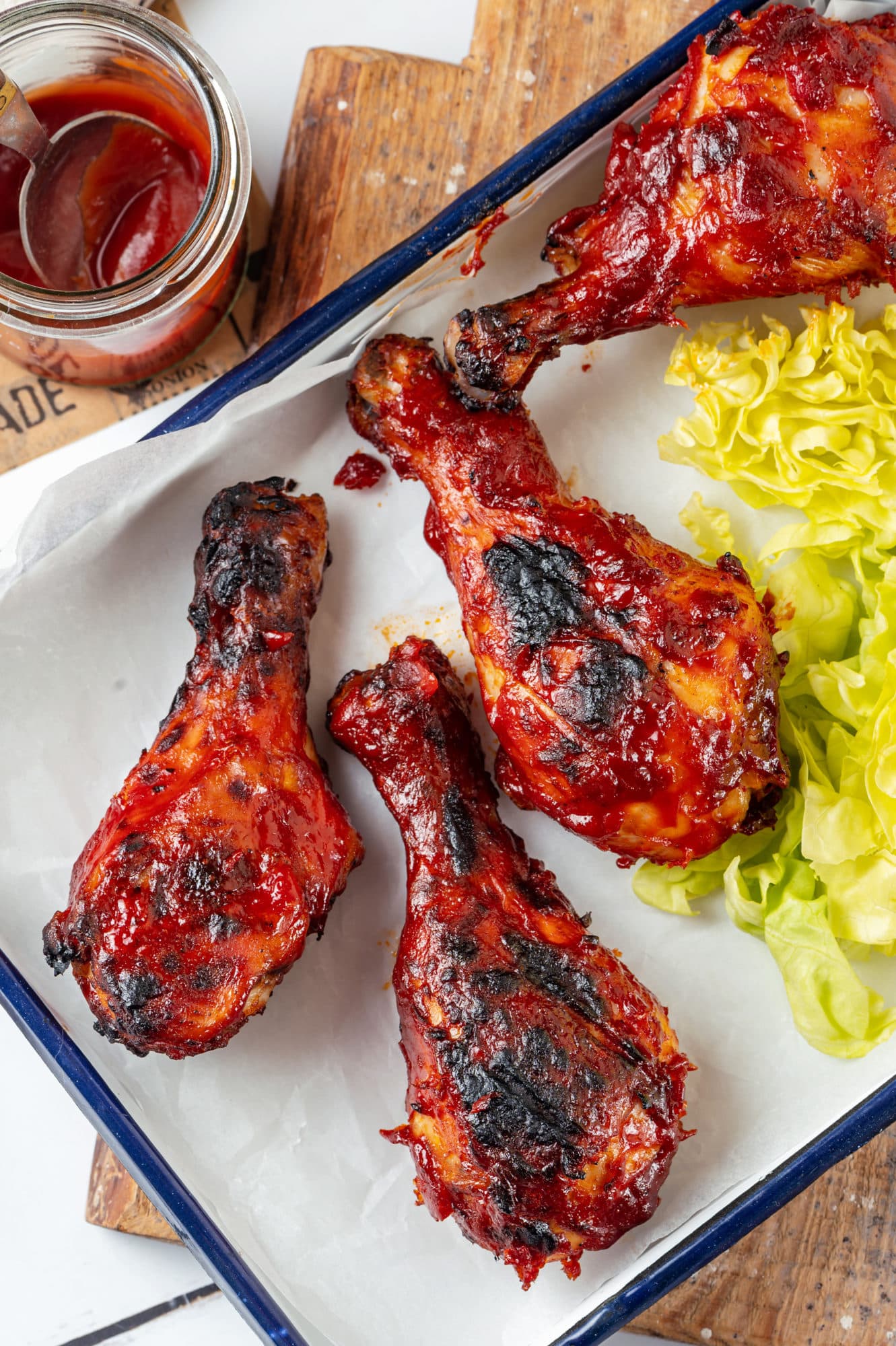 chicken-drumsticks-on-a-baking-tray-on-a-cutting-board-with-lettuce