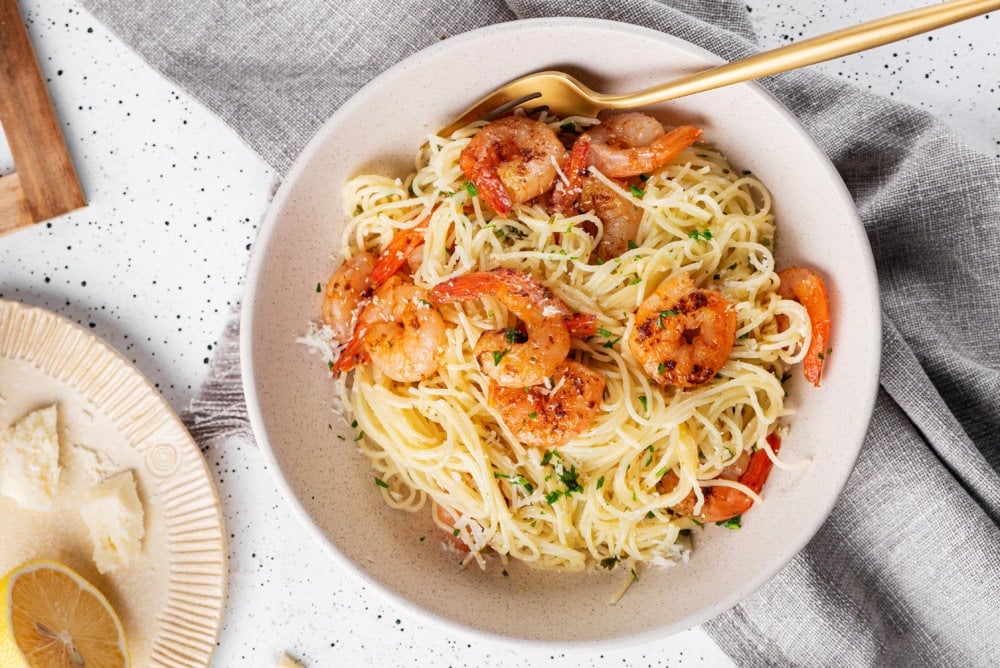 capellini-shrimp-in-a-bowl-with-a-gold-fork-on-a-grey-towel