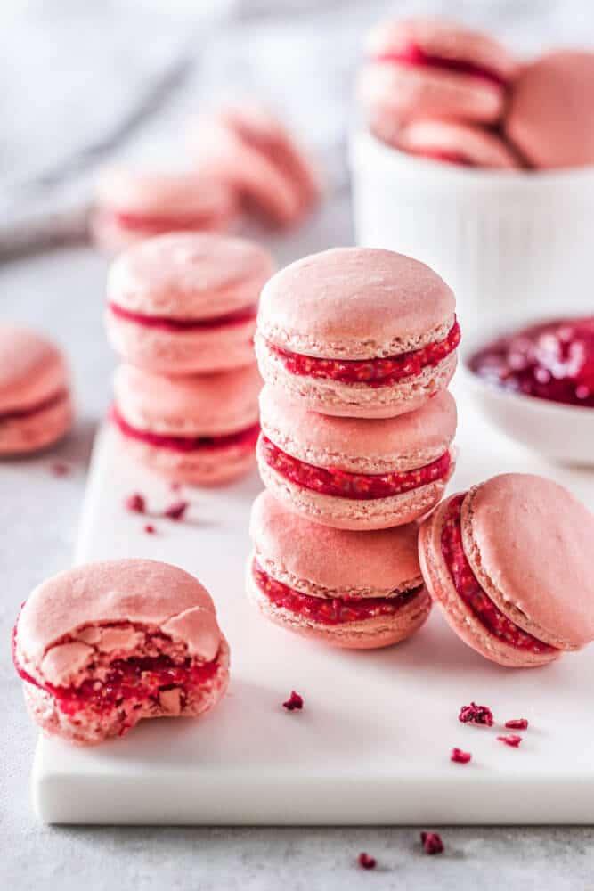raspberry-macarons-stacked-on-white-board