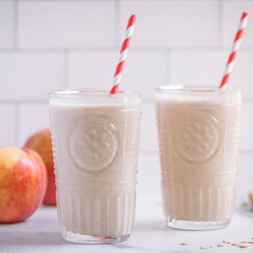 Smoothie of apple pie in two glasses with straws.