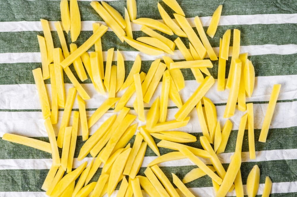 Chopped potatoes fries on a kitchen towel.