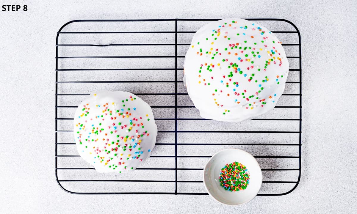 Easter bread on a wire rack topped with sweet icing and colorful sprinkles. 