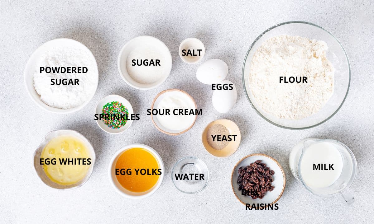 easter bread paska ingredients in small bowls flour sour cream powdered sugar sugar salt two white large eggs colored sprinkles egg whites and yolks water raisins cup of milk yeast. 