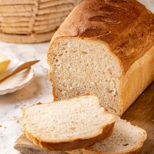 Freshly baked and sliced whole wheat bread with a basket on the side.