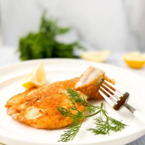 pan-seared-tilapia-on-a-white-plate-with-a-fork