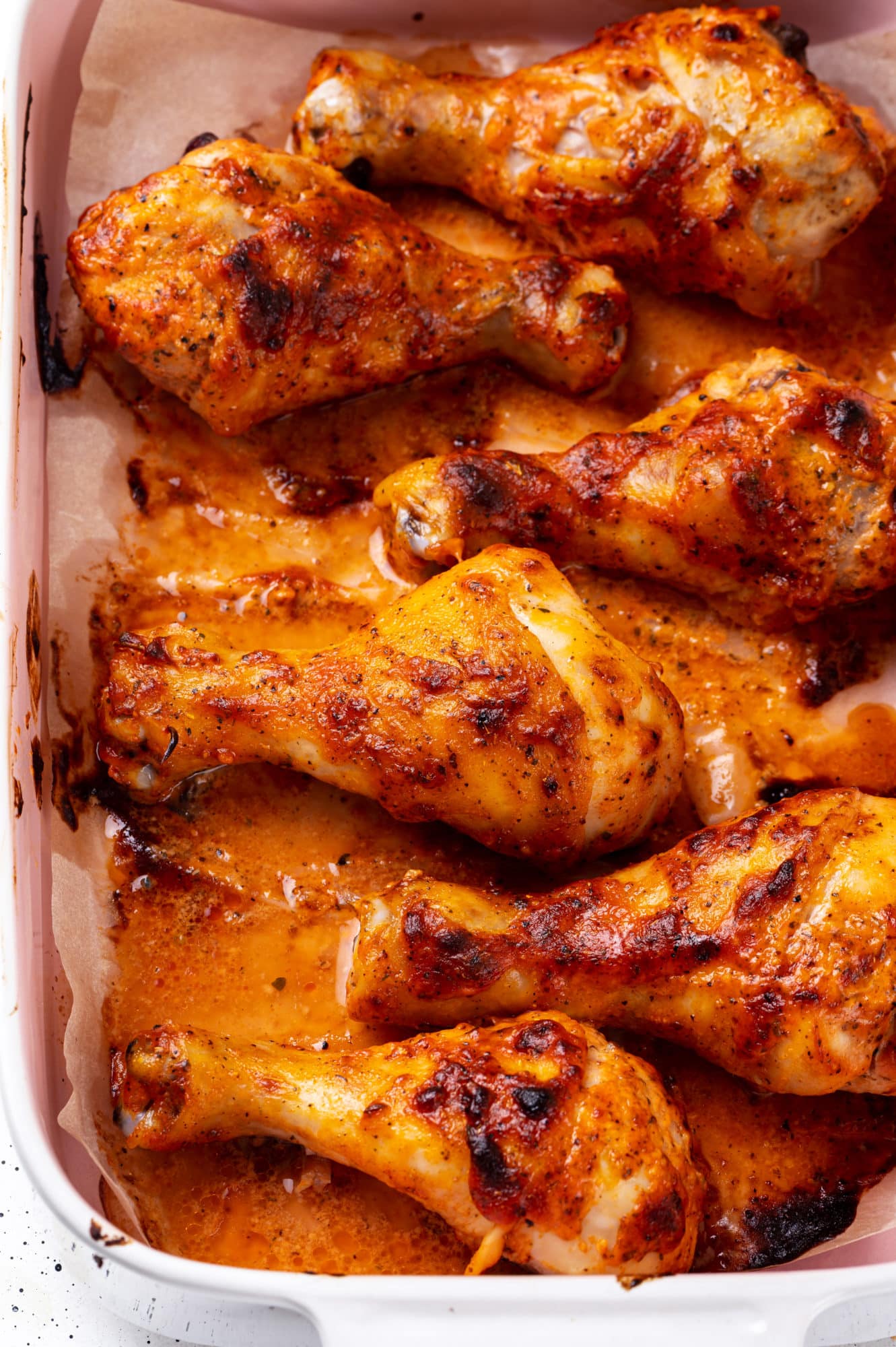 close up of baked chicken wings cooked in a baking tray with parchment paper.