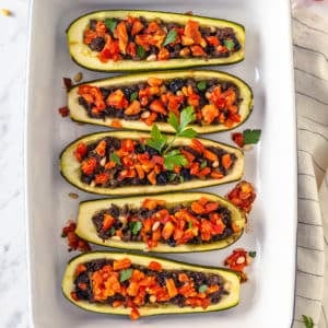 a baking tray with stuffed and baked zucchini boats in it.