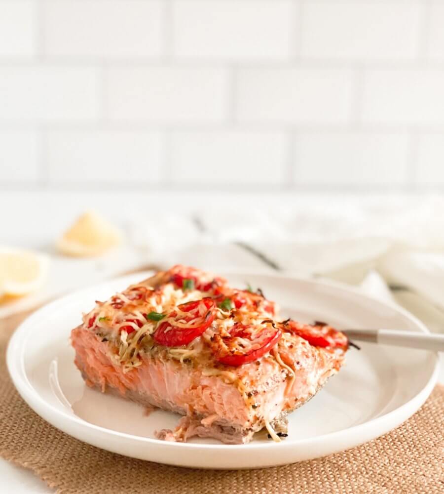 baked-salmon-and-tomatoes-slice-on-a-white-plate-on-a-brown-towel