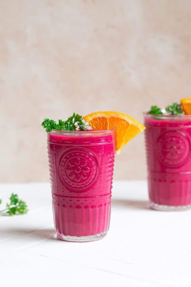 beet-and-berry-smoothie-in-glasses-with-dill-and-an-orange-wedge-on-top