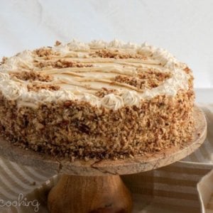 honey-cake-final-product-on-a-wooden-cake-stand-with-a-striped-brown-towel-in-the-background