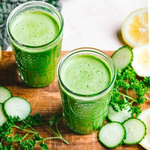green-detox-juice-in-clear-glasses-on-a-wooden-board-with-ingredients-around