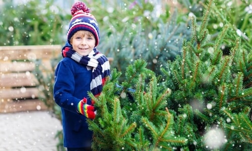 christmas-tree-in-the-snow-with-a-kid-wearing-winter-gear