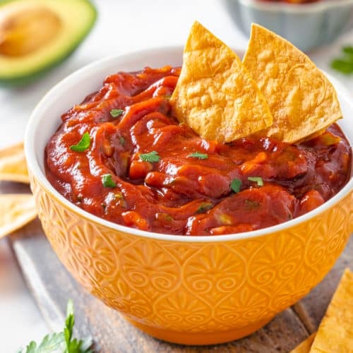 a bowl of avocado salsa with chips in the salsa.