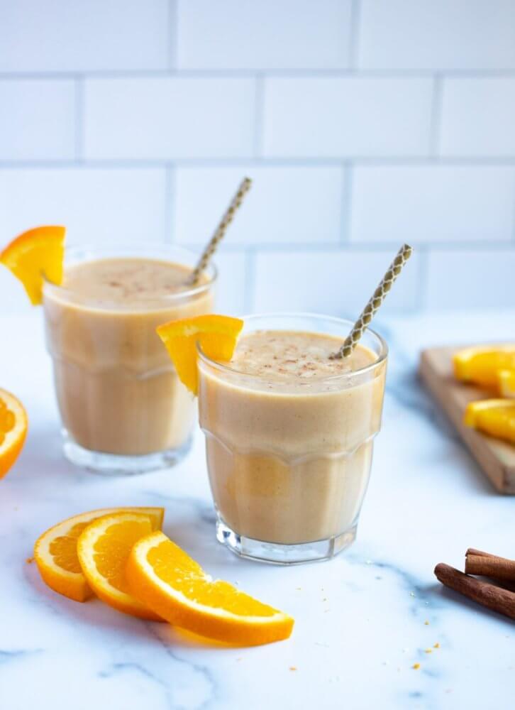 orange-collagen-smoothie-in-glasses-with-straws-and-orange-wedges-on-the-rim-and-on-the-countertop