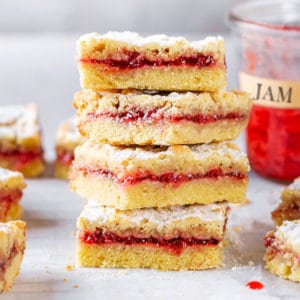 jam-bars-stacked-on-parchment-paper-with-jam-in-the-background