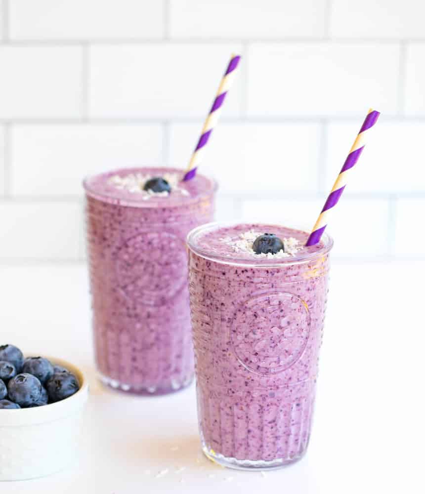 coconut-blueberry-smoothie-in-two-glasses-with-straws-and-blueberries-on-the-side