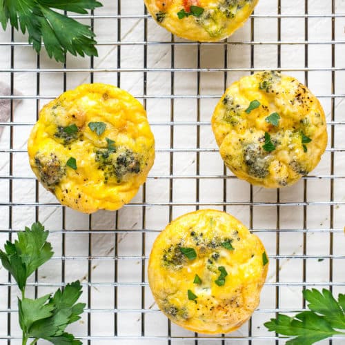 Frittata egg muffins on a wire rack with parsley around.