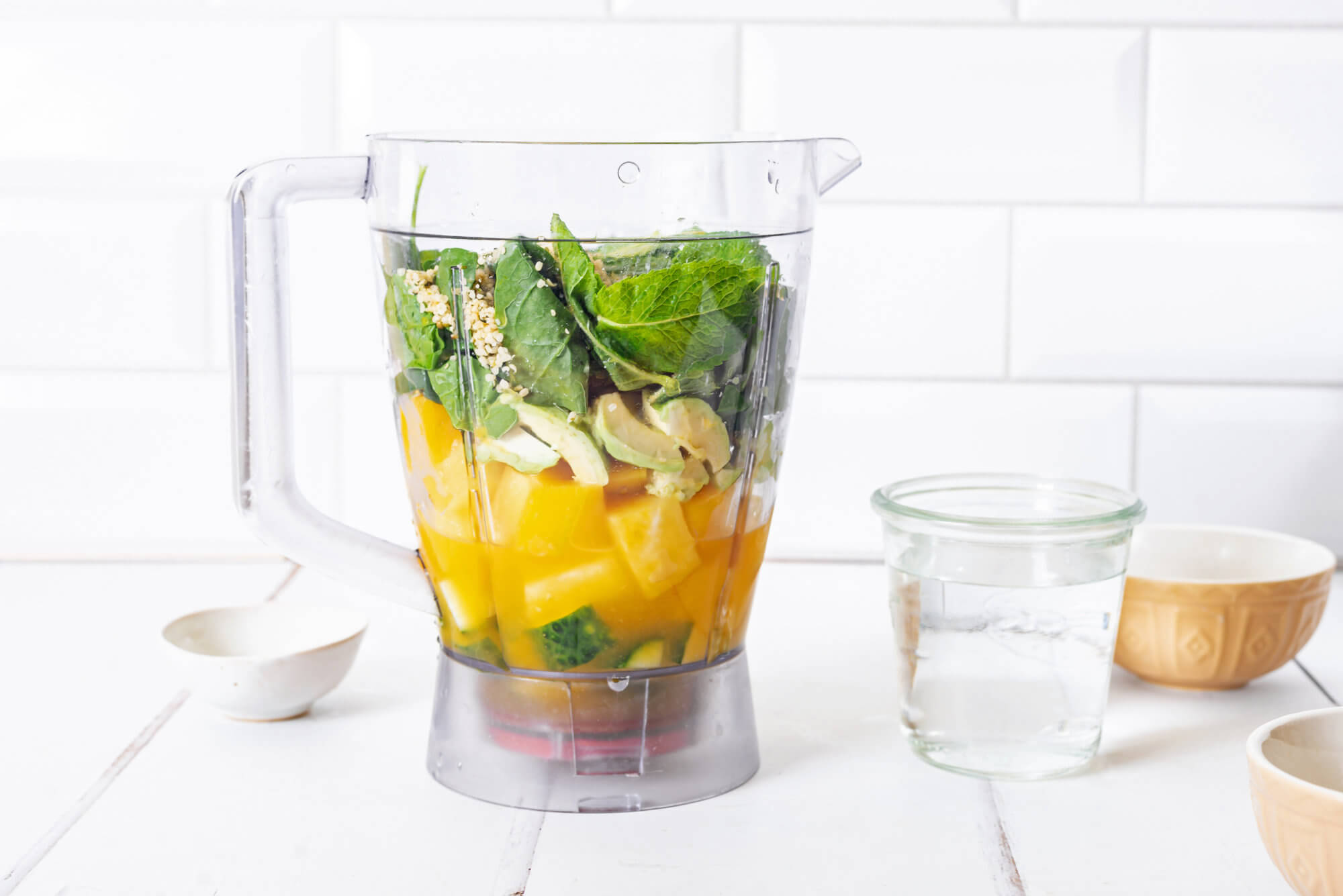 smoothie-ingredients-in-a-blender-with-a-glass-of-water-on-the-side